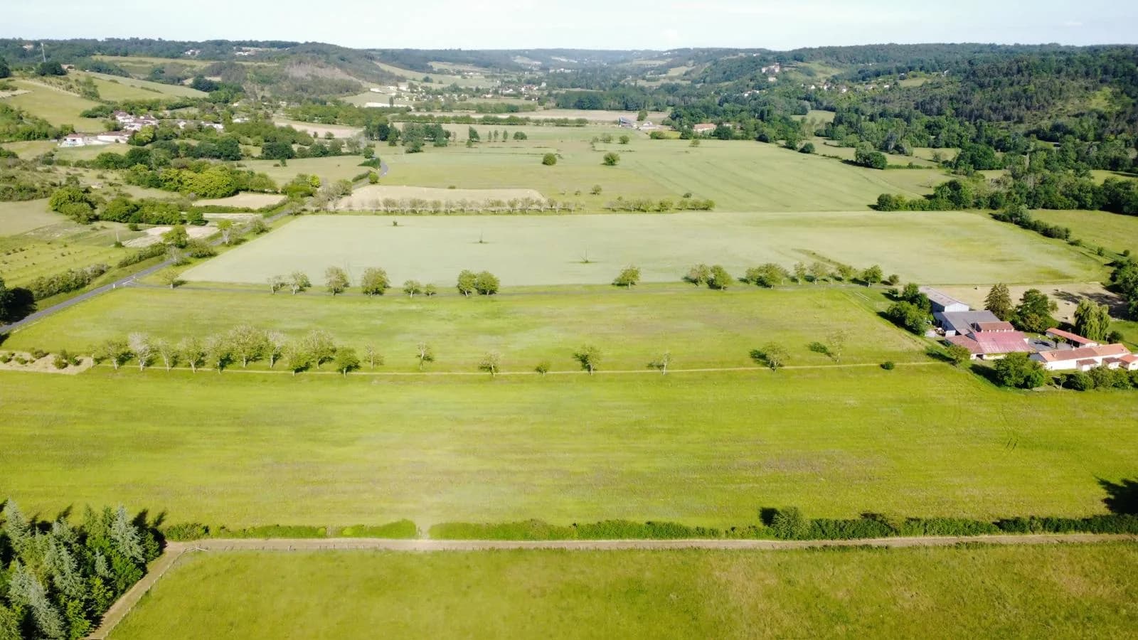 Vue aérienne des parcelles aujourd'hui : prairies, alignements de noyers et bâtiments agricoles